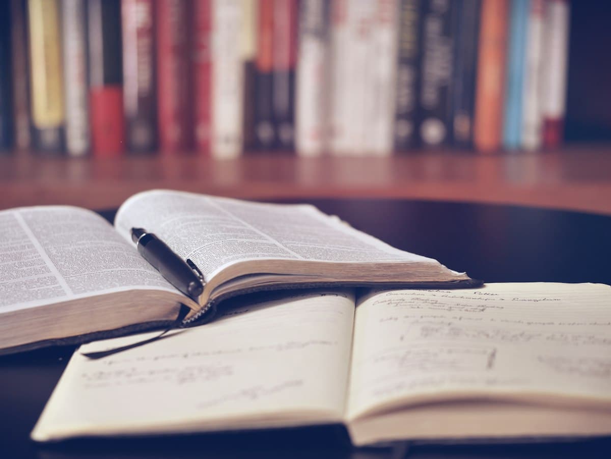 Open books and a notebook on a study desk